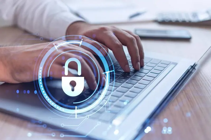 An icon of a padlock sits over an image of a man's hands over a keyboard. Elevated Networks provides data security services.